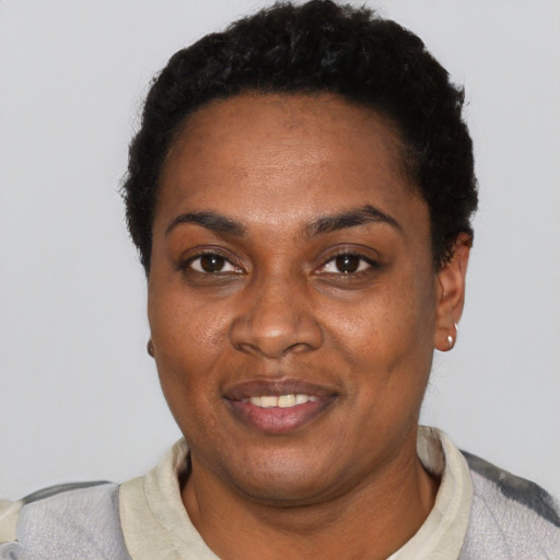 Joyful black adult female with short  black hair and brown eyes