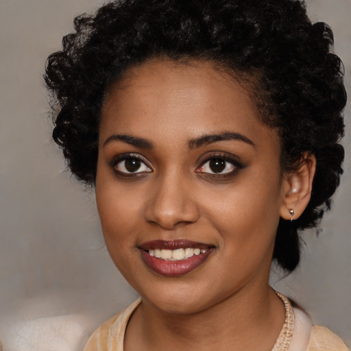 Joyful black young-adult female with medium  brown hair and brown eyes