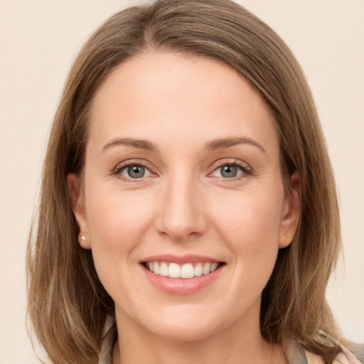 Joyful white young-adult female with long  brown hair and grey eyes