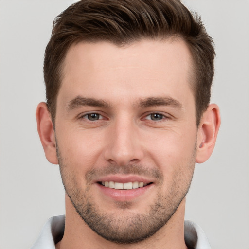 Joyful white young-adult male with short  brown hair and grey eyes