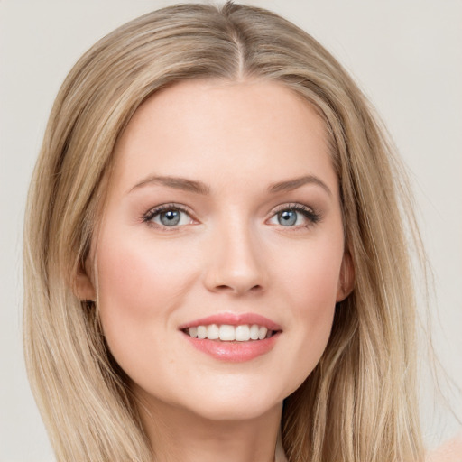 Joyful white young-adult female with long  brown hair and blue eyes