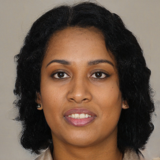 Joyful black young-adult female with long  black hair and brown eyes