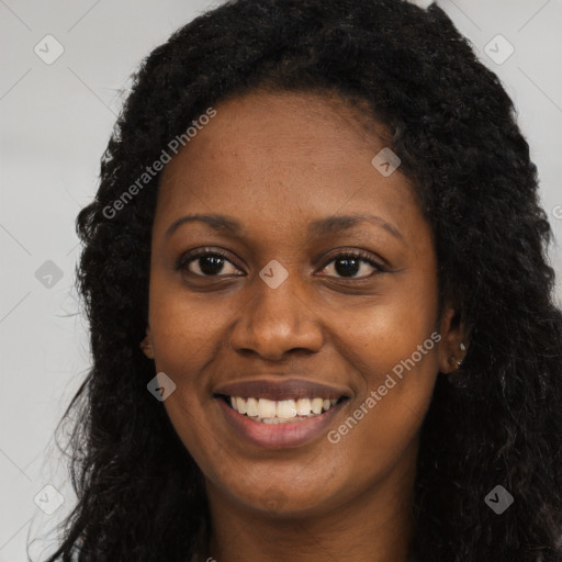 Joyful black young-adult female with long  brown hair and brown eyes