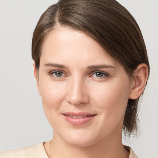 Joyful white young-adult female with medium  brown hair and grey eyes