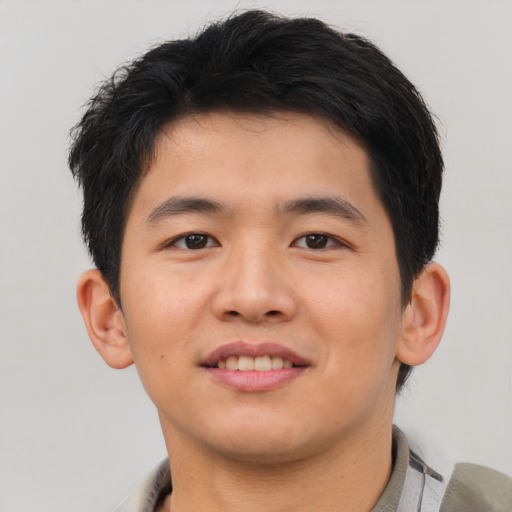 Joyful asian young-adult male with short  brown hair and brown eyes