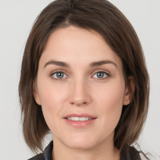 Joyful white young-adult female with medium  brown hair and grey eyes