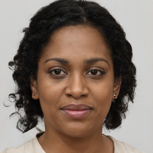 Joyful black adult female with medium  brown hair and brown eyes