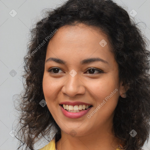 Joyful black young-adult female with long  brown hair and brown eyes