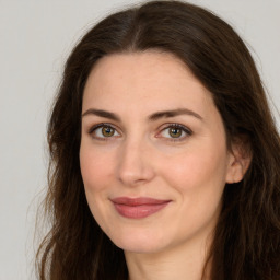 Joyful white adult female with long  brown hair and brown eyes