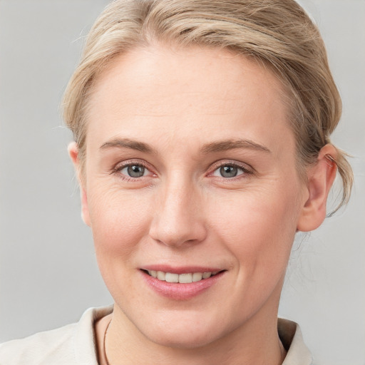 Joyful white young-adult female with short  brown hair and blue eyes