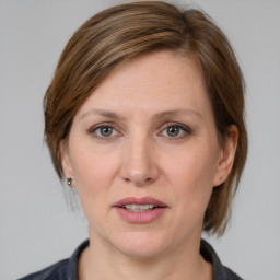 Joyful white adult female with medium  brown hair and grey eyes