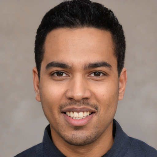 Joyful latino young-adult male with short  black hair and brown eyes