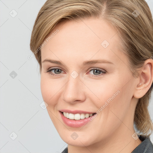 Joyful white young-adult female with medium  brown hair and grey eyes