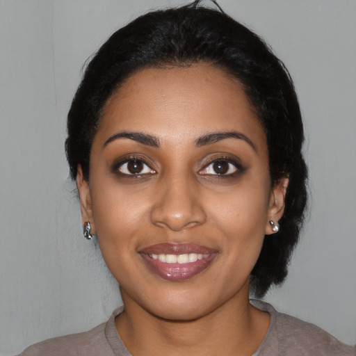 Joyful black young-adult female with medium  black hair and brown eyes