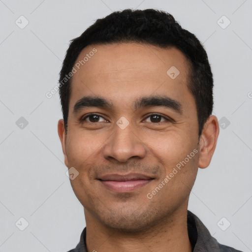 Joyful latino young-adult male with short  black hair and brown eyes