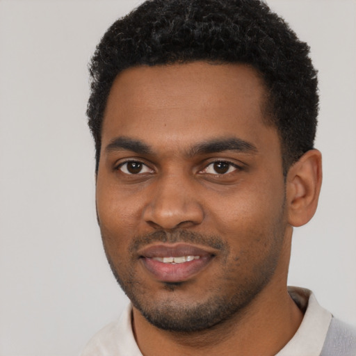 Joyful black young-adult male with short  black hair and brown eyes