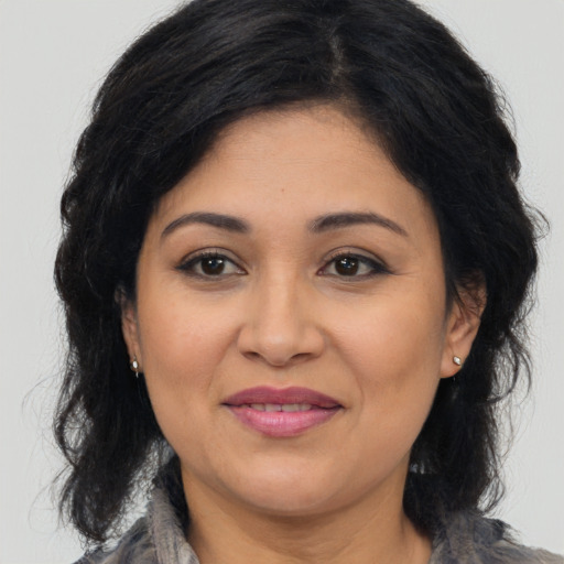 Joyful latino adult female with medium  brown hair and brown eyes