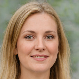 Joyful white young-adult female with long  brown hair and green eyes