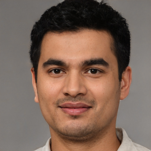 Joyful latino young-adult male with short  black hair and brown eyes