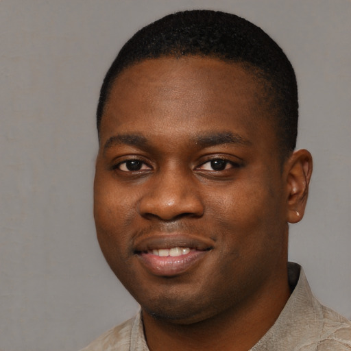 Joyful black young-adult male with short  black hair and brown eyes