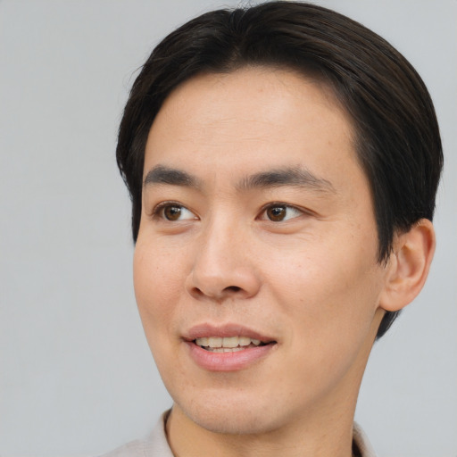 Joyful asian young-adult male with short  brown hair and brown eyes