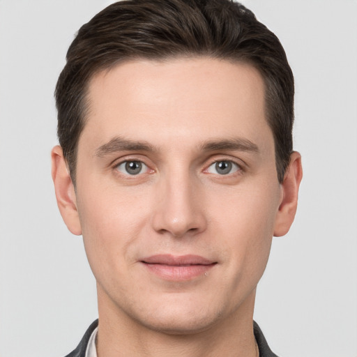 Joyful white young-adult male with short  brown hair and grey eyes