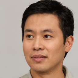 Joyful asian young-adult male with short  black hair and brown eyes