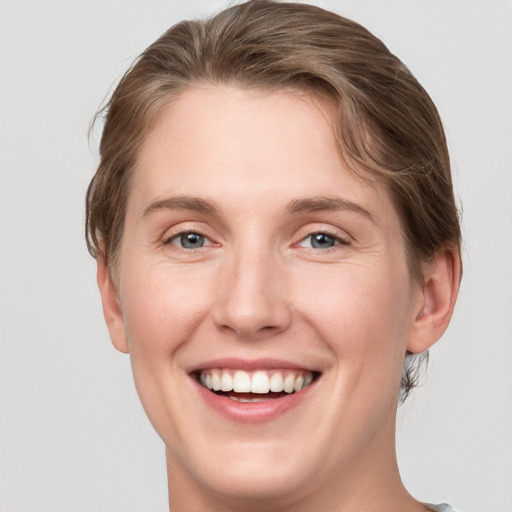 Joyful white young-adult female with short  brown hair and grey eyes