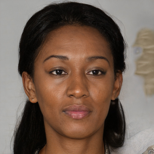 Joyful black adult female with medium  brown hair and brown eyes