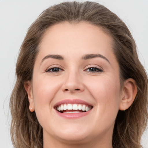 Joyful white young-adult female with long  brown hair and grey eyes