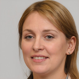 Joyful white adult female with medium  brown hair and blue eyes