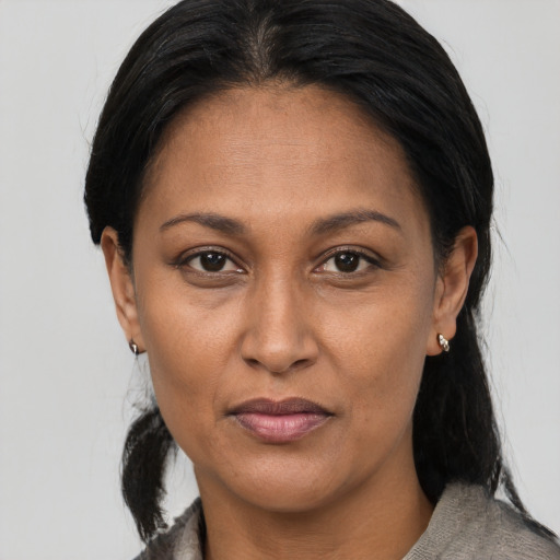 Joyful latino adult female with medium  brown hair and brown eyes