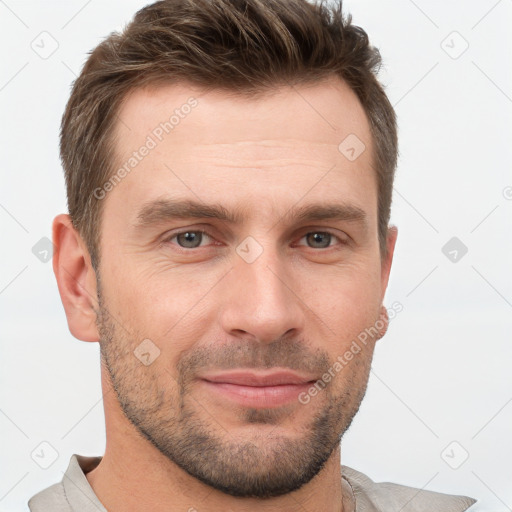 Joyful white young-adult male with short  brown hair and grey eyes