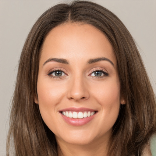 Joyful white young-adult female with long  brown hair and brown eyes