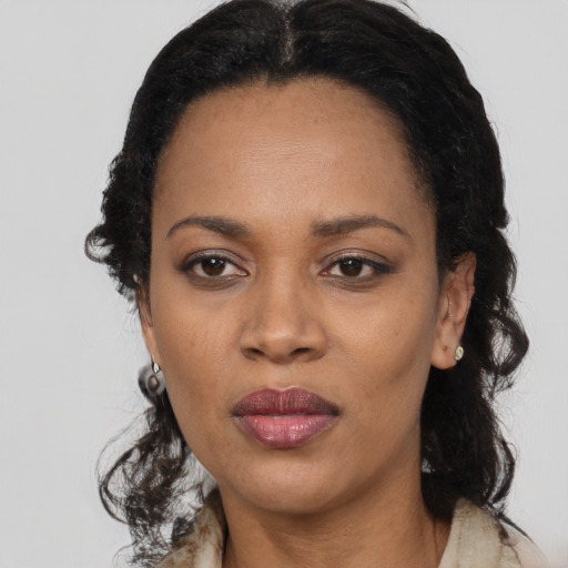 Joyful black adult female with long  black hair and brown eyes