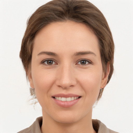 Joyful white young-adult female with medium  brown hair and grey eyes