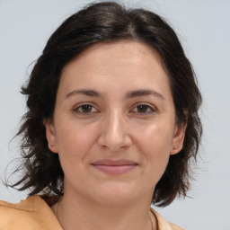 Joyful white adult female with medium  brown hair and brown eyes