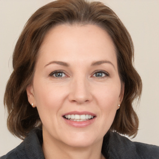 Joyful white adult female with medium  brown hair and grey eyes