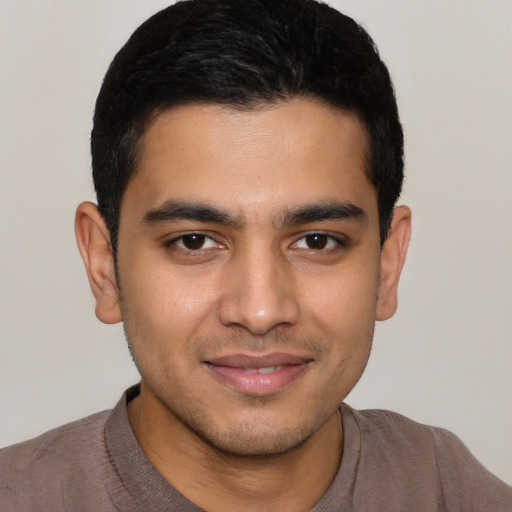 Joyful latino young-adult male with short  black hair and brown eyes
