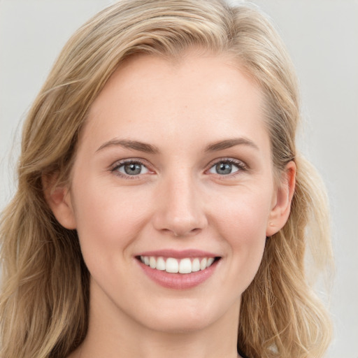 Joyful white young-adult female with long  brown hair and blue eyes