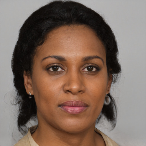 Joyful black adult female with medium  brown hair and brown eyes