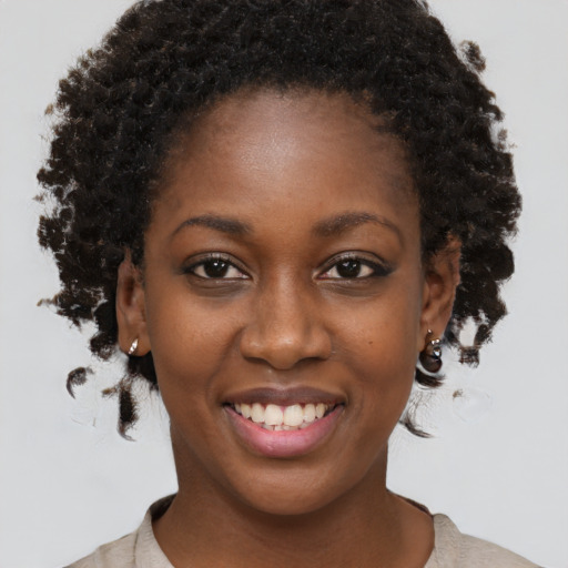 Joyful black young-adult female with medium  brown hair and brown eyes
