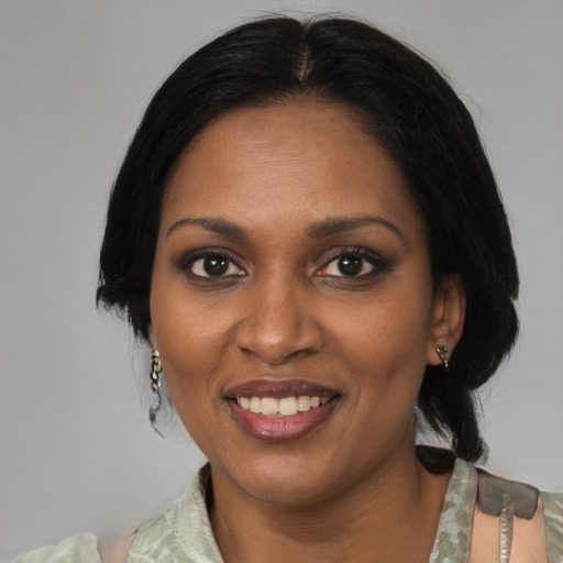Joyful black adult female with medium  black hair and brown eyes