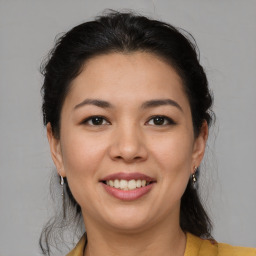 Joyful latino young-adult female with medium  brown hair and brown eyes