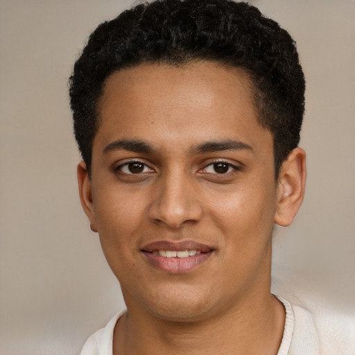 Joyful black young-adult male with short  black hair and brown eyes