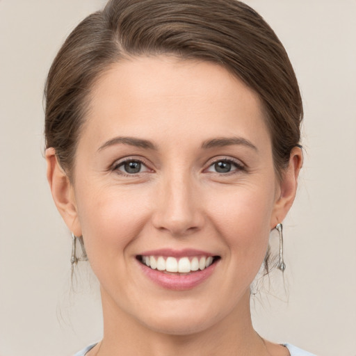 Joyful white young-adult female with medium  brown hair and grey eyes