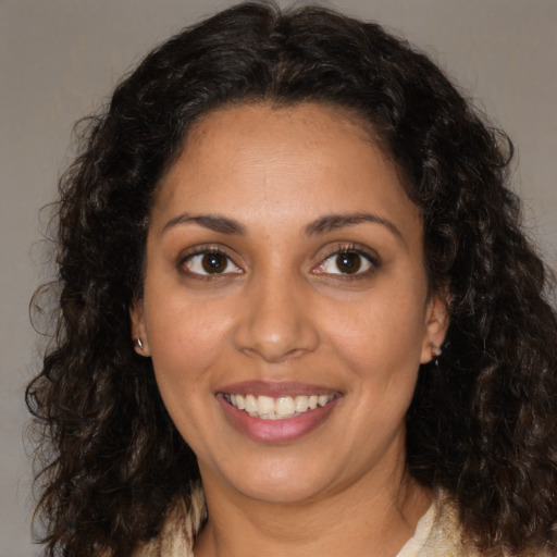 Joyful latino young-adult female with medium  brown hair and brown eyes