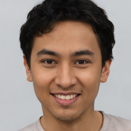 Joyful latino young-adult male with short  brown hair and brown eyes