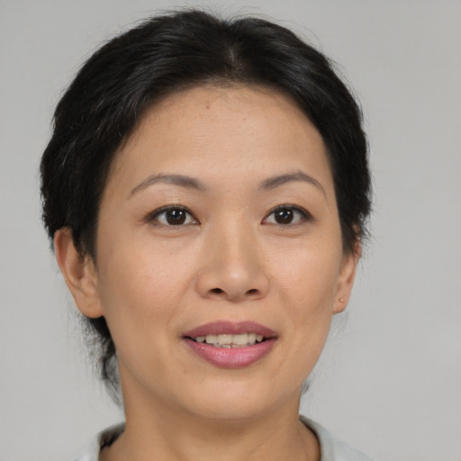 Joyful asian young-adult female with short  brown hair and brown eyes