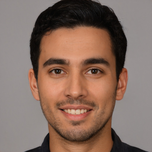 Joyful white young-adult male with short  black hair and brown eyes